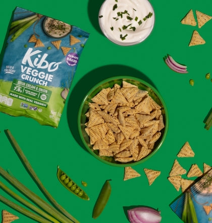 A bowl of Veggie Crunch Chips by KIBO, with the bag and dip nearby.